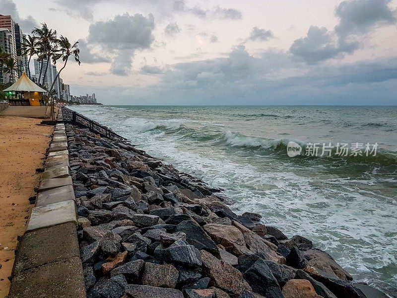 在巴西累西腓的Boa Viagem海滩，强大的蓝色海浪正向海浪块前进